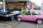 Pink Vauxhall Corsa crashes into a black Aston Martin DBS.jpg