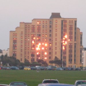 Windows of the building reflecting the sunlight looks like its on fire.