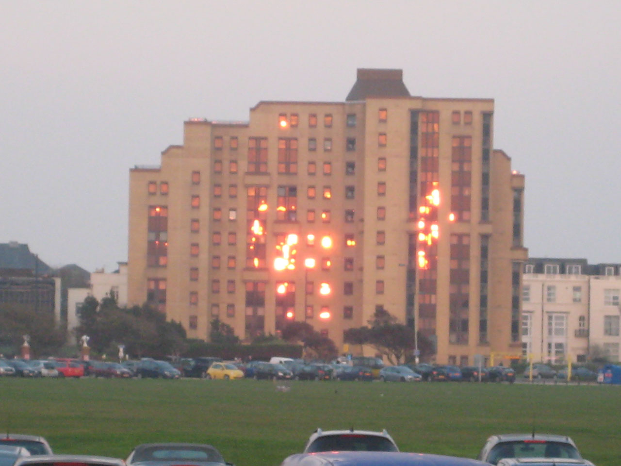 Windows of the building reflecting the sunlight looks like its on fire.